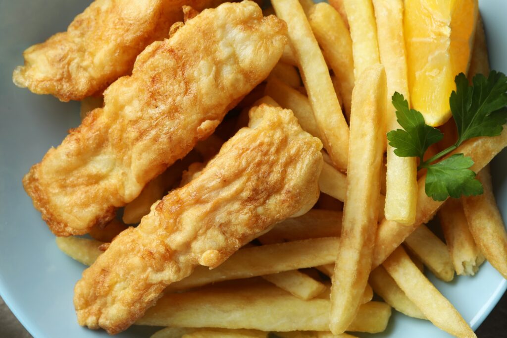 Plate with fried fish and chips, close up